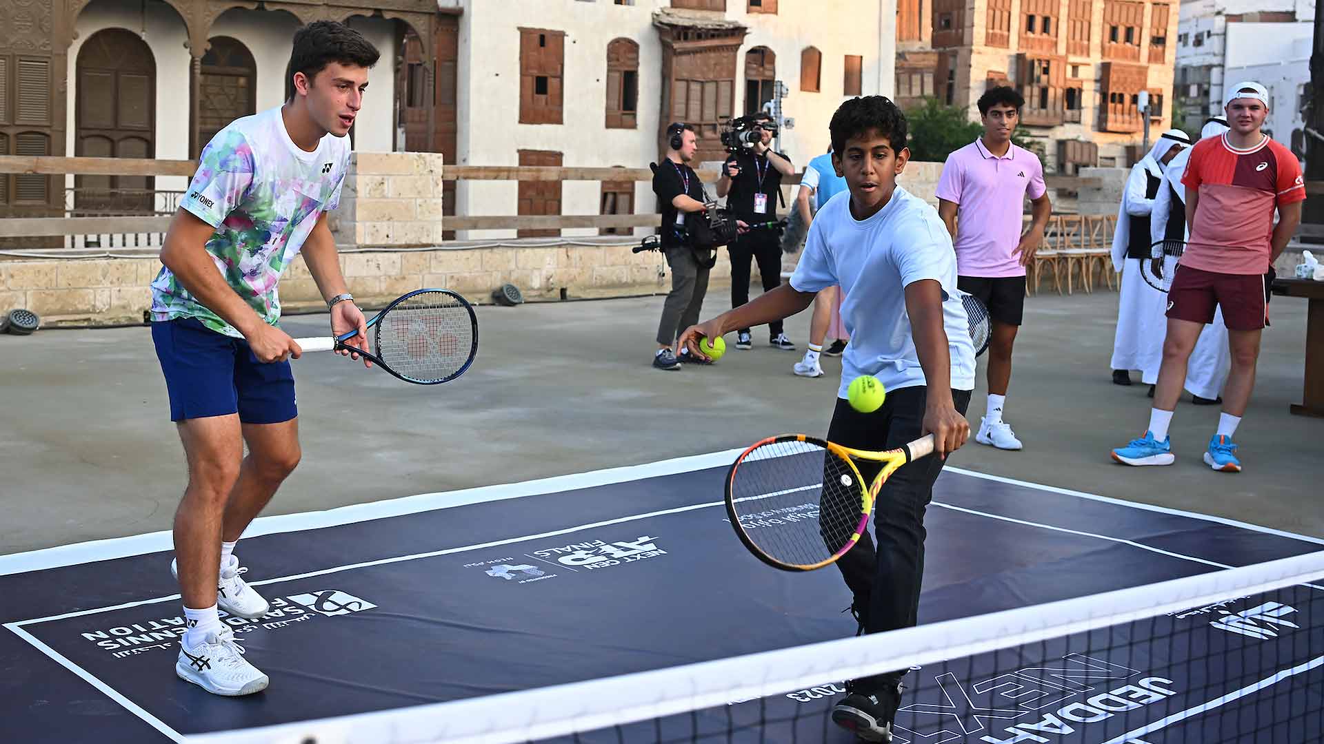 Luca Nardi teams up with a junior Jeddah tennis player during a pre-tournament visit to Al-Balad.